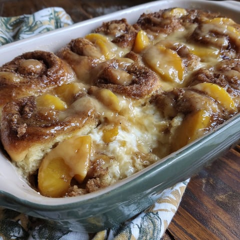 A casserole with peaches and cinnamon rolls.