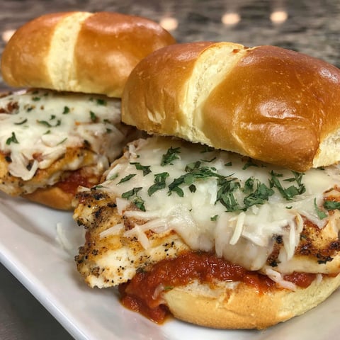 Two marinara chicken sandwiches on a plate.