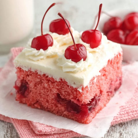 A slice of cake with cherries on top.