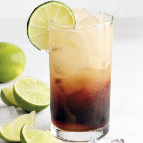 A glass of dark and stormy drink.