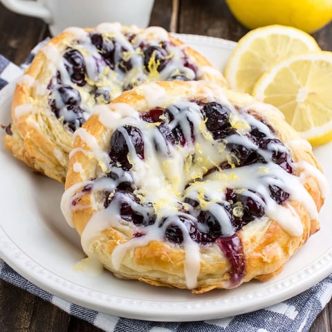 Two homemade blueberry lemon danishes on a plate.