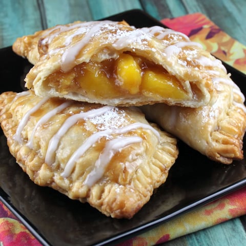 Two biscoff peach empanadas on a plate.