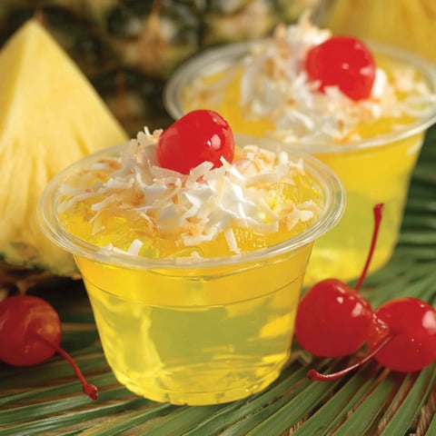 Two small cups of pineapple jello shots.