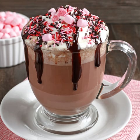 A cup of dark chocolate latte with a drizzle of chocolate.