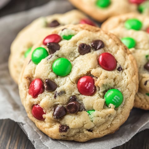 A plate of chocolate chip cookies with green and red M&Ms.
